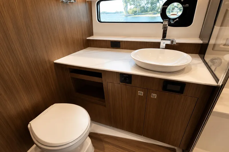 Slide: The Image of Luxurious bathroom in 2024 Cruisers Yachts 50 GLS with modern fixtures and wood accents. - 34