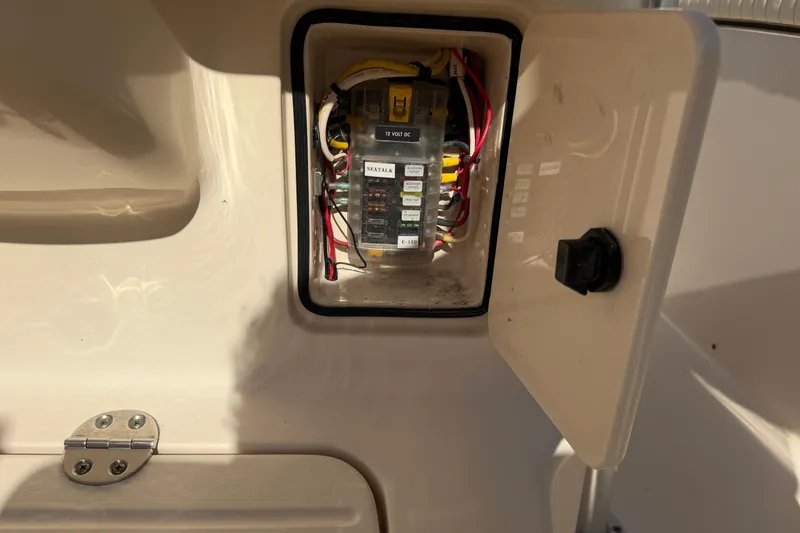 Slide: The Image of Electrical panel inside a 2010 Grady-White Canyon 336 boat, showing wiring and fuses. - 19