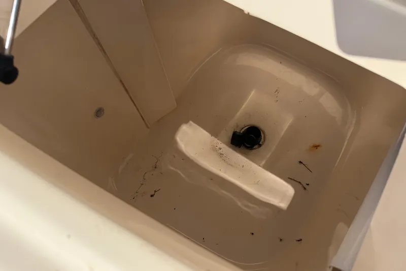 Slide: The Image of Livewell interior of 2010 Grady-White Canyon 336 boat, showing drain and minor debris. - 27