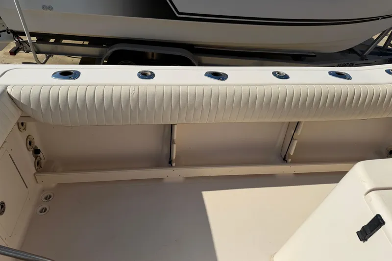 Slide: The Image of 2010 Grady-White Canyon 336 boat interior with cushioned seating and rod holders. - 37