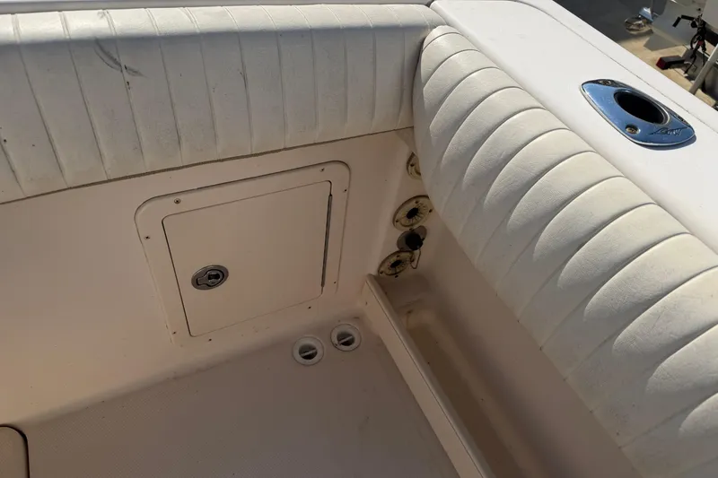 Slide: The Image of 2010 Grady-White Canyon 336 boat interior with cushioned seating and storage compartment. - 38