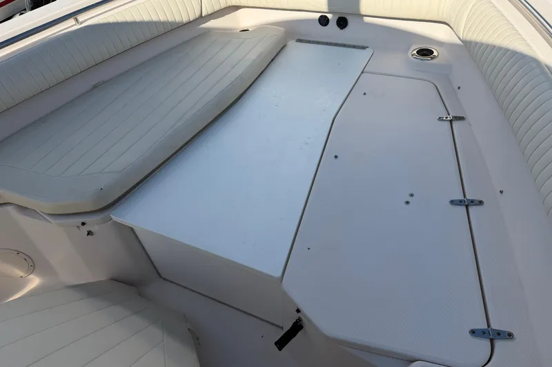 Slide: The Image of 2010 Grady-White Canyon 336 boat interior with cushioned seating and storage compartments. - 49