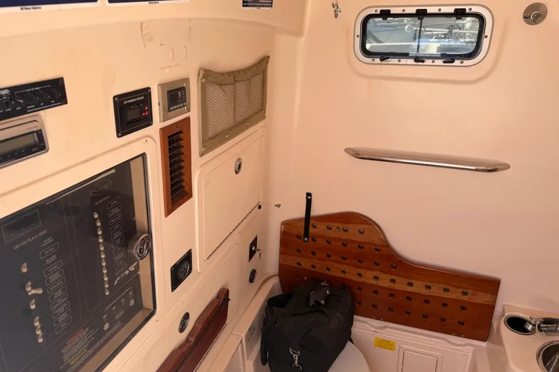 Slide: The Image of Interior of 2010 Grady-White Canyon 336 boat, featuring control panel and porthole window. - 55