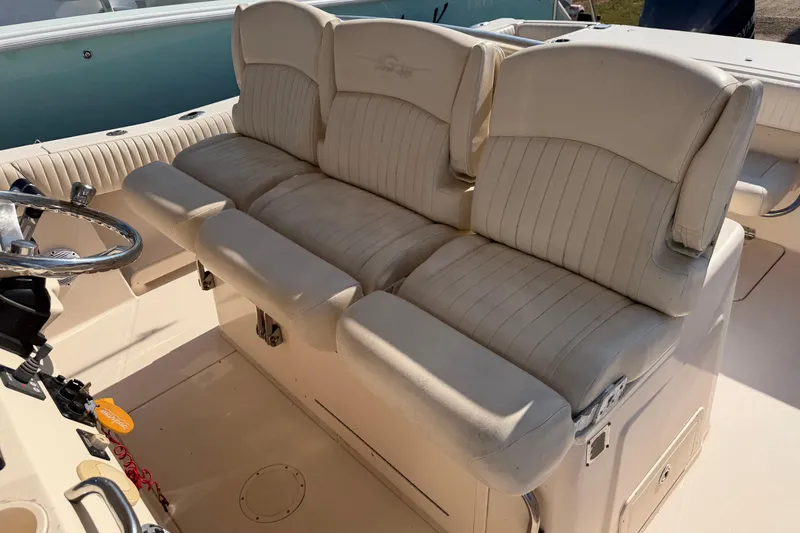Slide: The Image of 2010 Grady-White Canyon 336 boat interior with beige seating and steering wheel. - 64