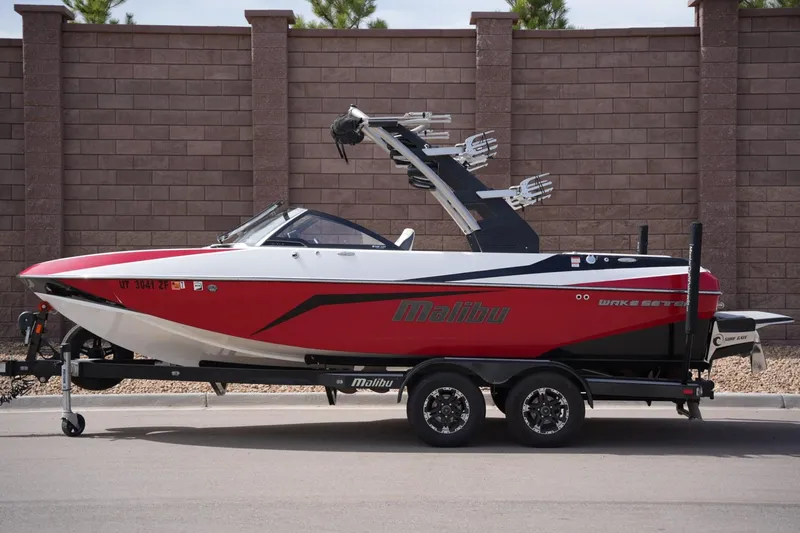 The Image of 2018 Malibu Wakesetter 21 VLX boat on trailer, red color. - 1