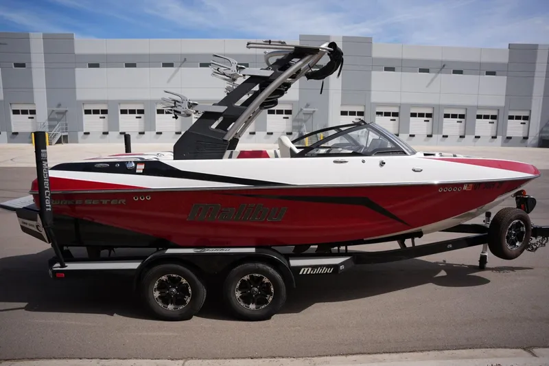 Slide: The Image of 2018 Malibu Wakesetter 21 VLX boat on trailer in front of building. - 5