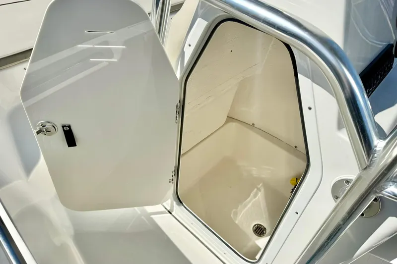 Slide: The Image of 2026 Key West 189 FS boat storage compartment with open door and stainless steel railing. - 21
