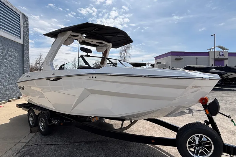 Slide: The Image of 2026 Tigé Z3 boat on trailer, sleek white design, parked outdoors under blue sky. - 13