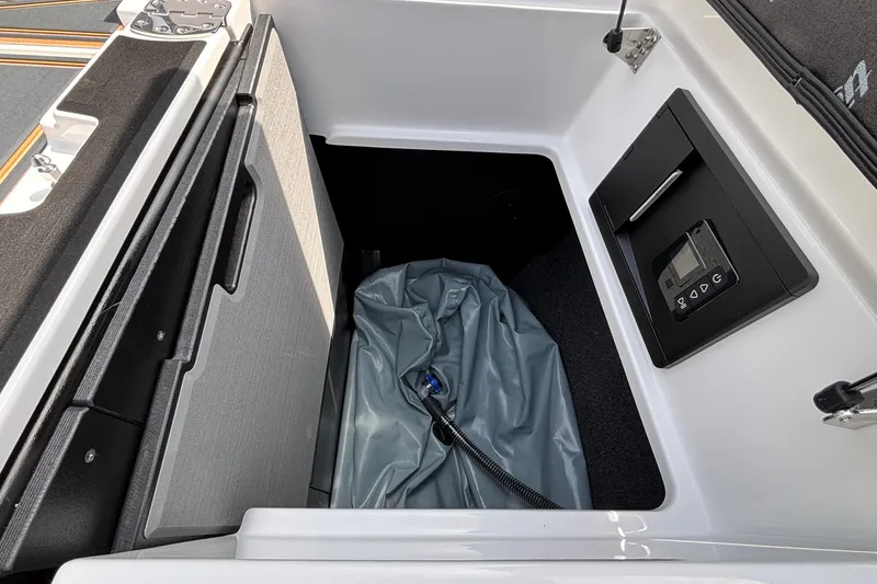 Slide: The Image of Storage compartment in 2026 Tigé Z3 boat with control panel and gray cover. - 26