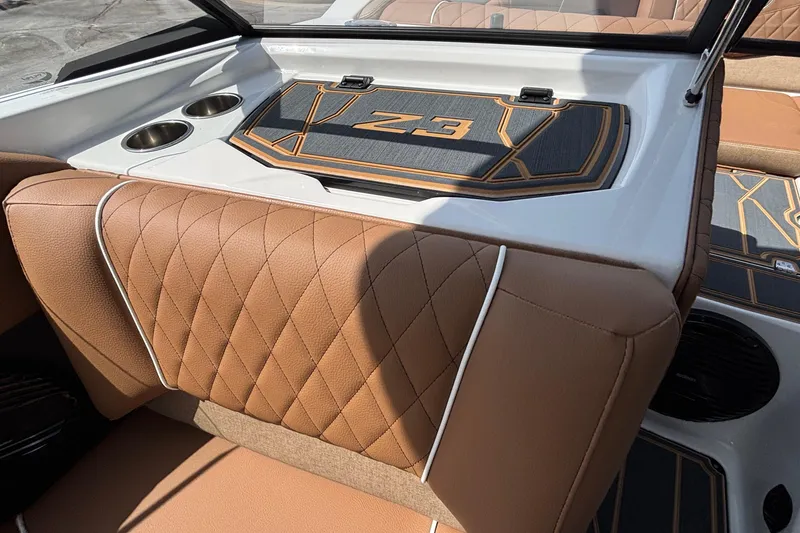 Slide: The Image of 2026 Tigé Z3 boat interior with brown quilted seats and cup holders. - 44
