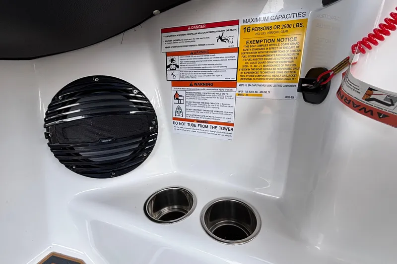Slide: The Image of 2026 Tigé Z3 boat interior with speaker, warning labels, and cup holders. - 58