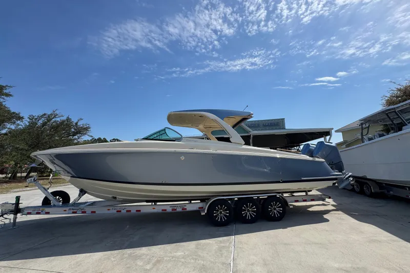 The Image of 2026 Chris-Craft Launch 35 GT boat on trailer under clear blue sky. - 1