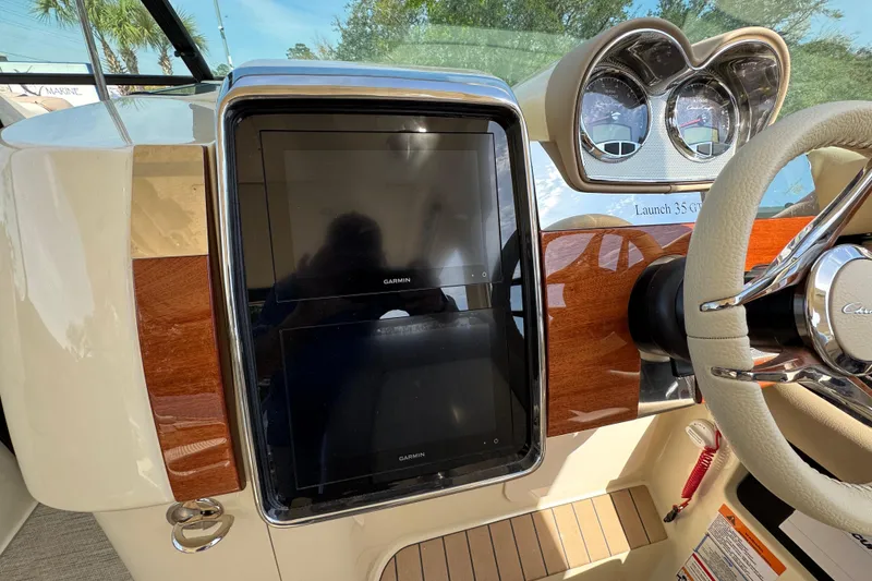 Slide: The Image of 2026 Chris-Craft Launch 35 GT dashboard with Garmin displays and elegant wood finish. - 26