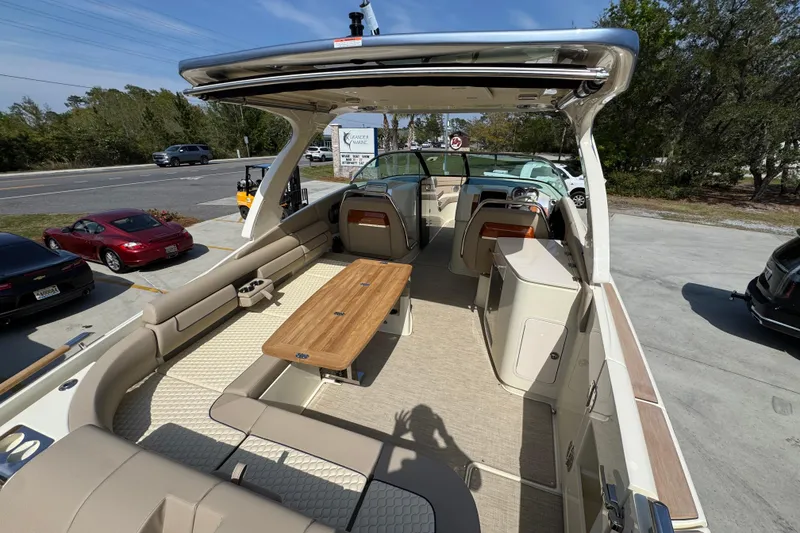 Slide: The Image of 2026 Chris-Craft Launch 35 GT boat interior with seating and wooden table, parked outdoors. - 41