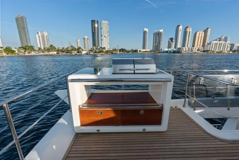 Slide: The Image of Luxury yacht Azimut 66 (2017) with city skyline view, featuring outdoor kitchen. - 10