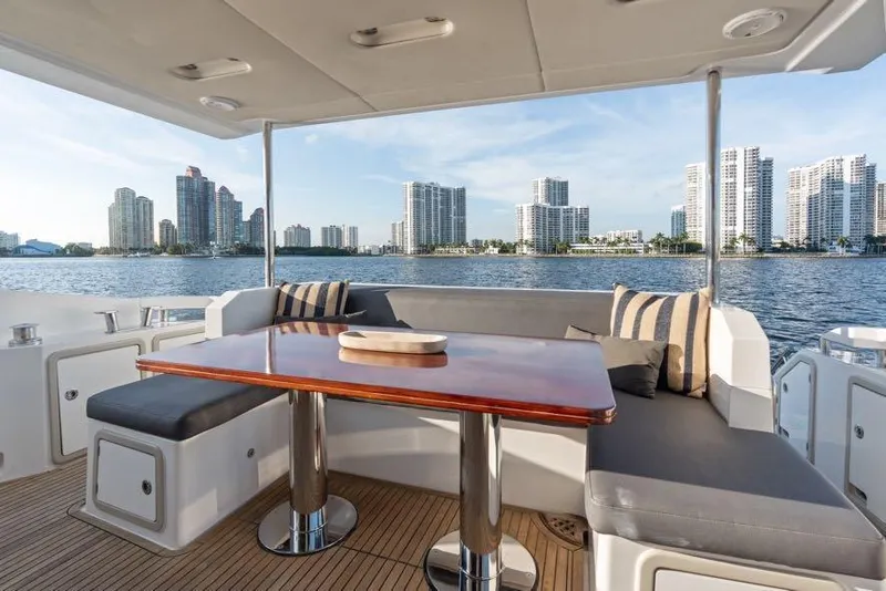 Slide: The Image of Luxurious Azimut 66 yacht deck with city skyline view, featuring elegant seating and table. - 15