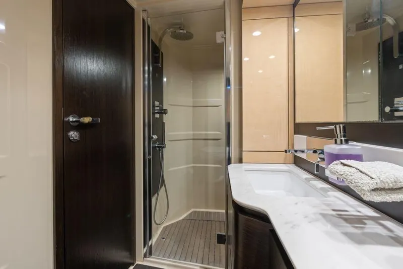 Slide: The Image of Luxurious bathroom in a 2017 Azimut 66 yacht, featuring a modern shower and sleek vanity. - 28