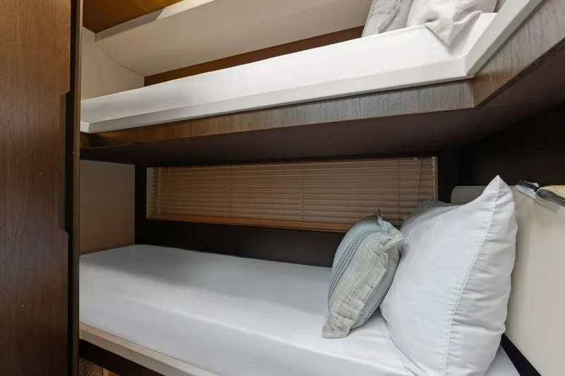 Slide: The Image of Bunk beds in 2017 Azimut 66 yacht cabin with wooden accents and cozy pillows. - 35