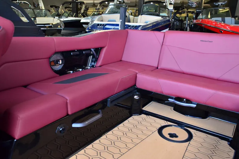Slide: The Image of 2023 MasterCraft NXT23 interior with red seating and modern design in showroom. - 12