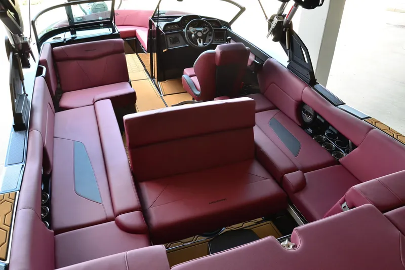 Slide: The Image of 2023 MasterCraft NXT23 boat interior with luxurious red seating and modern dashboard design. - 15