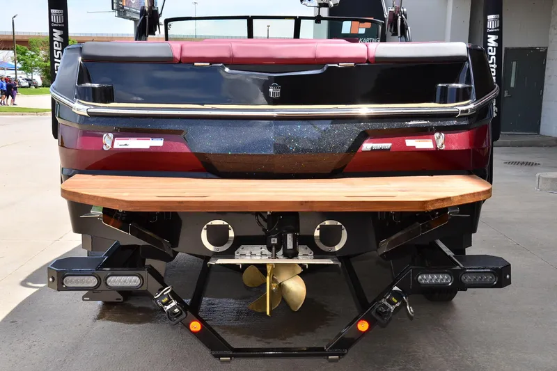 Slide: The Image of 2023 MasterCraft NXT23 boat rear view with wooden swim platform and propeller. - 3