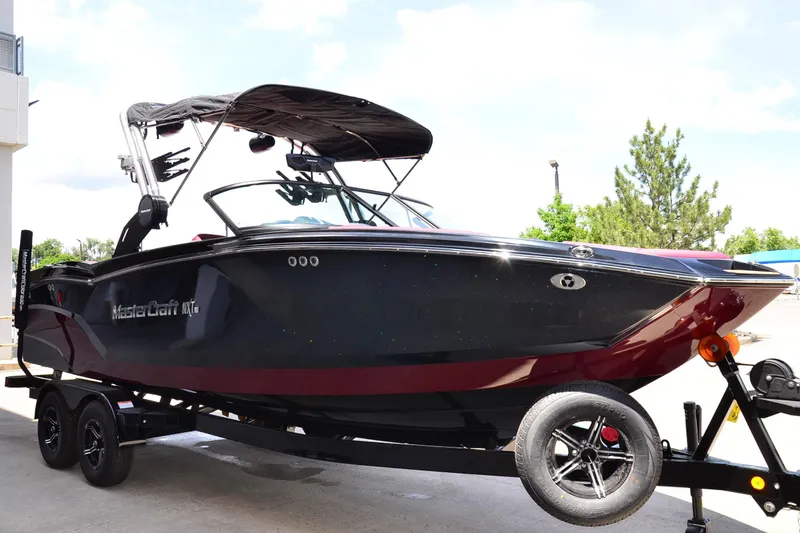 Slide: The Image of 2023 MasterCraft NXT23 boat on trailer, sleek black and red design, ready for adventure. - 6