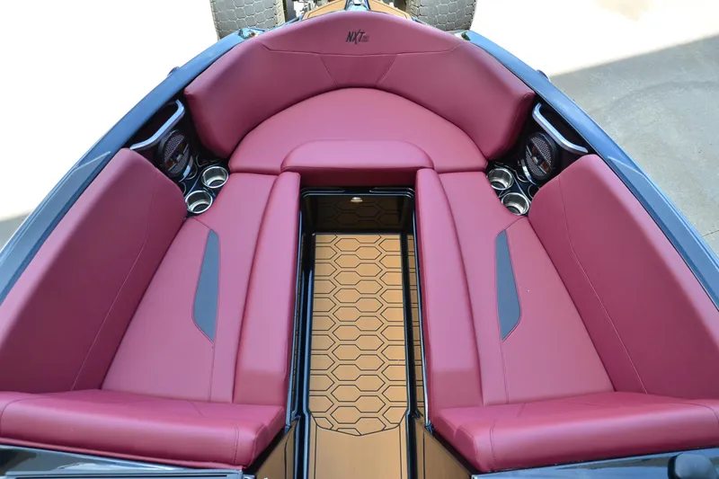 Slide: The Image of 2023 MasterCraft NXT23 boat interior with red seating and hexagonal floor design. - 8