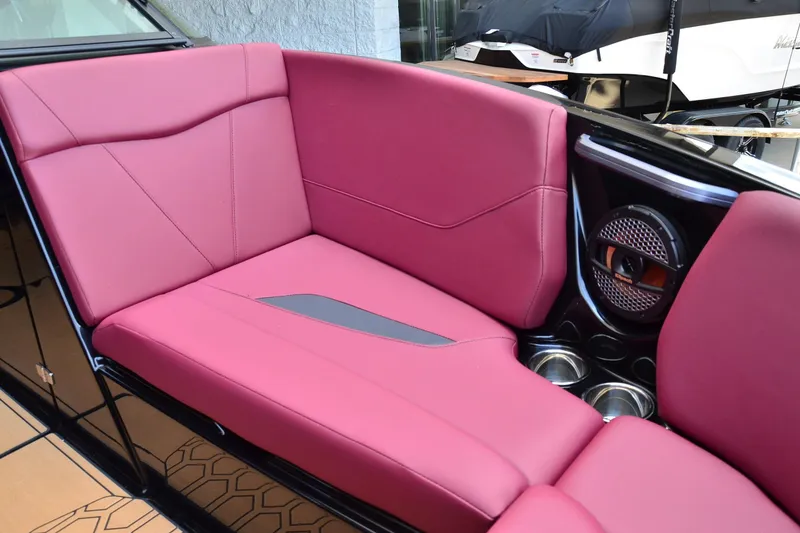 Slide: The Image of 2023 MasterCraft NXT23 boat interior with pink seating and speaker system. - 9