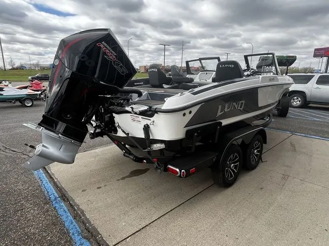 Slide: The Image of 2026 Lund 202 PRO-V GL Sport boat on trailer, parking lot view. - 8