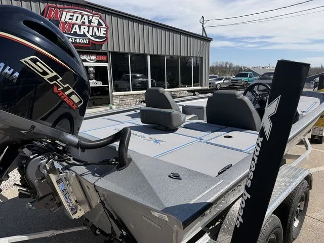 Slide: The Image of 2026 Xpress H20 boat parked outside a marine shop. - 3