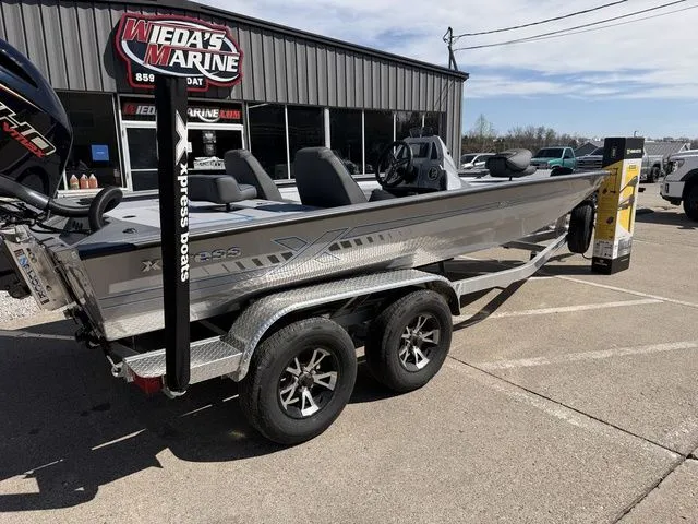 Slide: The Image of 2026 Xpress H20 boat parked outside a marine store. - 4