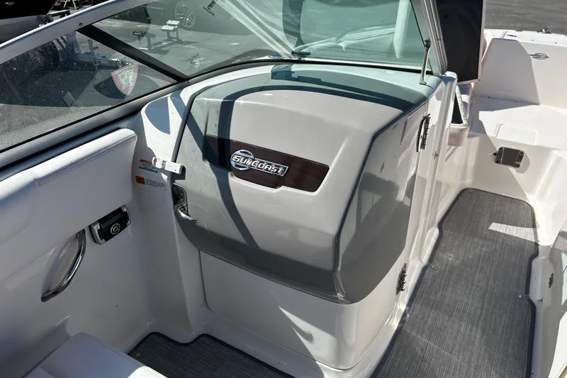 Slide: The Image of 2016 Chaparral 210 Suncoast boat interior with Suncoast logo, featuring sleek design and seating area. - 25