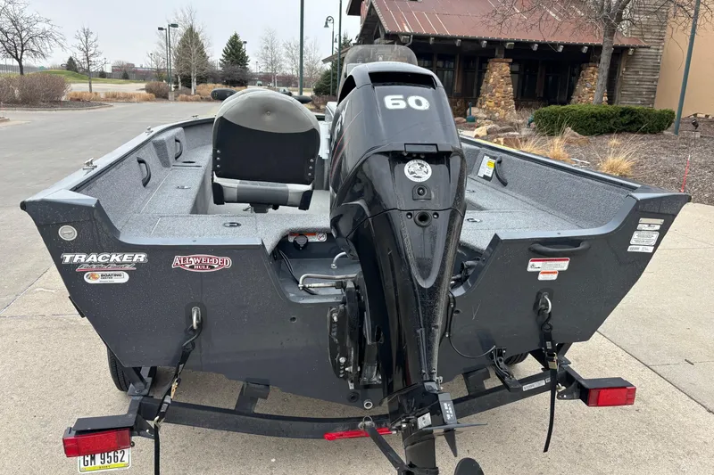 Slide: The Image of 2019 Tracker Pro Guide V-16 SC boat with 60 HP motor, parked outdoors. - 3