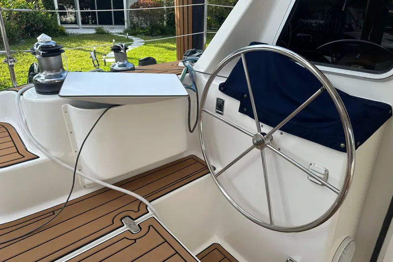 Slide: The Image of Steering wheel of a 2005 Seawind 1160 catamaran, featuring teak decking and winches. - 10