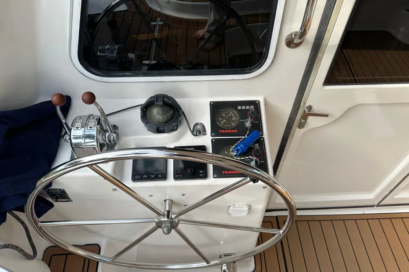 Slide: The Image of Steering wheel and controls of a 2005 Seawind 1160 catamaran, featuring Yanmar gauges. - 11