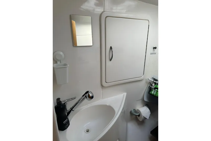 Slide: The Image of Cozy cabin bed in 2005 Seawind 1160 catamaran with blue bedding and pillows. - 22