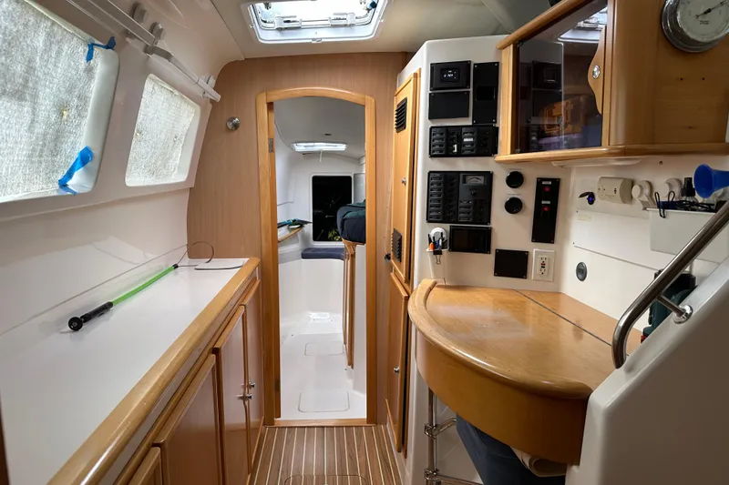Slide: The Image of Interior of a 2005 Seawind 1160 catamaran, featuring a control panel and wooden cabinetry. - 24