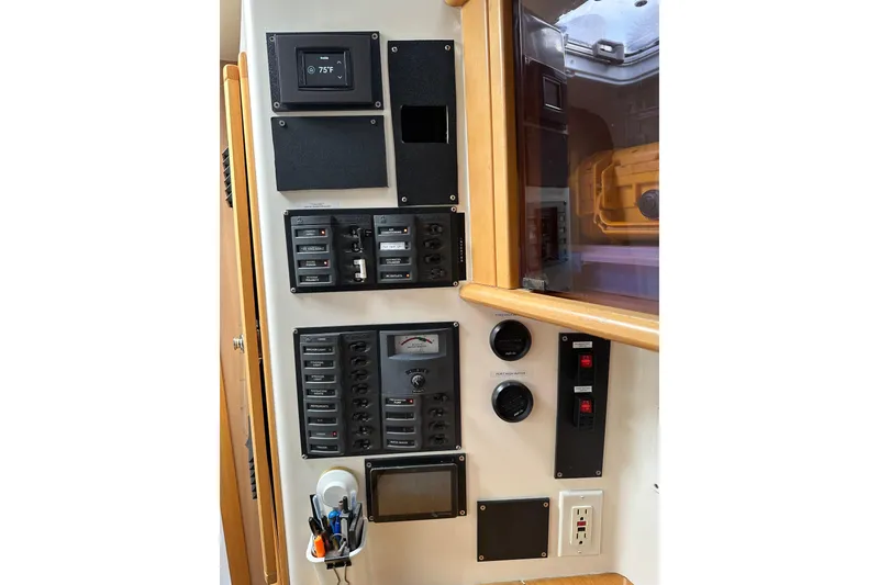Slide: The Image of Control panel of a 2005 Seawind 1160 catamaran, featuring switches and gauges. - 29