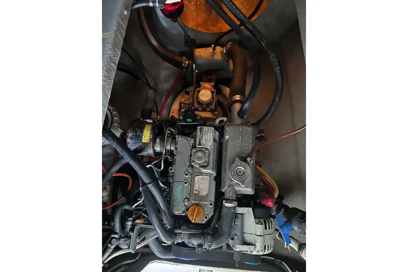 Slide: The Image of Engine compartment of a 2005 Seawind 1160 catamaran, showcasing mechanical components and wiring. - 31