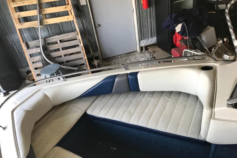 Slide: The Image of 1992 Seaswirl 190 Bowrider I/O interior with white and blue seating in a garage setting. - 18