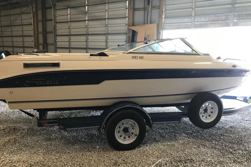 The Image of 1992 Seaswirl 190 Bowrider I/O boat on trailer in storage facility. - 2