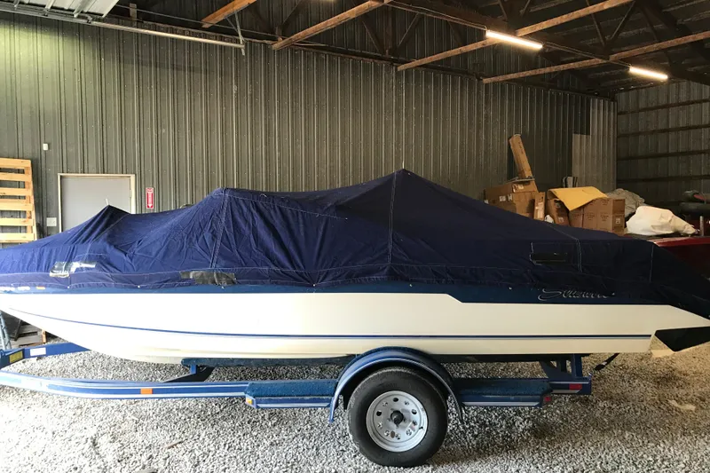 Slide: The Image of 1992 Seaswirl 190 Bowrider I/O boat covered in a garage on a trailer. - 28