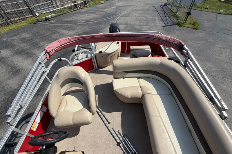 Slide: The Image of 2016 Sun Tracker Bass Buggy 18 DLX pontoon boat with beige seating and red accents. - 11