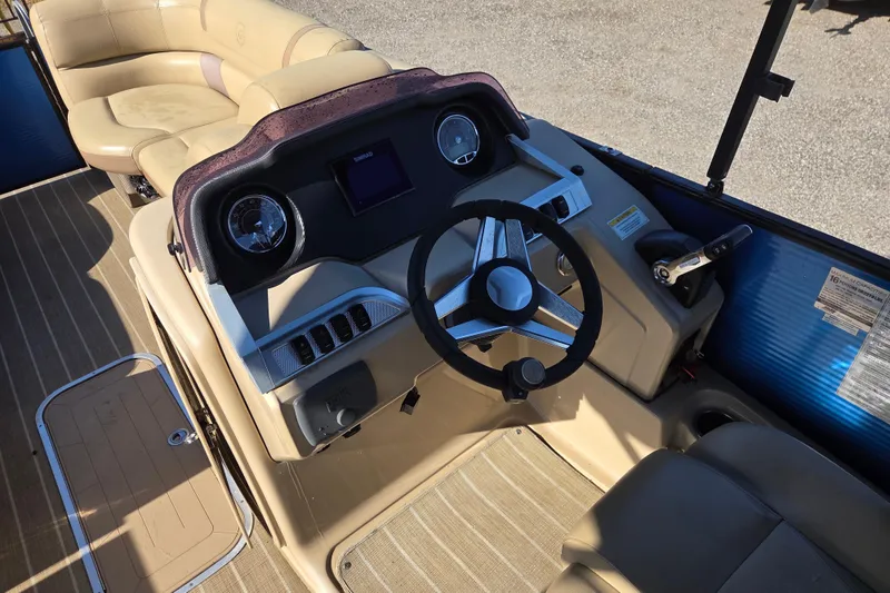 Slide: The Image of 2020 Godfrey AquaPatio 235 C boat interior with steering wheel and seating. - 18