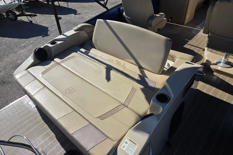 Slide: The Image of 2020 Godfrey AquaPatio 235 C boat interior with beige seating and cup holders. - 9