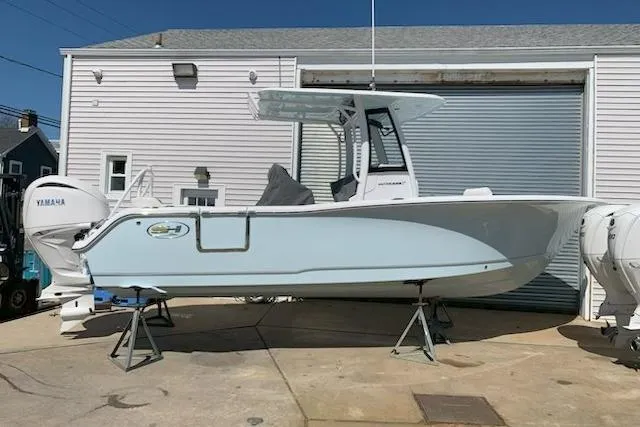 The Image of 2026 Sea Hunt Ultra 239 SE boat on stands, parked outside a garage. - 0
