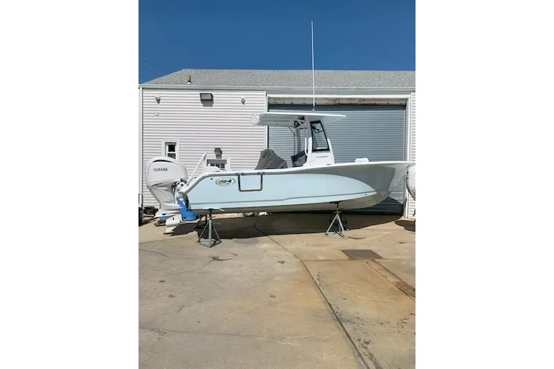 Slide: The Image of 2026 Sea Hunt Ultra 239 SE boat on stands outside a garage. - 23