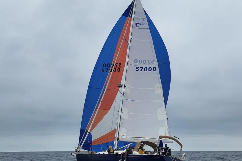 Slide: The Image of Sailing yacht Tartan 4000 (2016) with colorful sails on open sea under cloudy skies. - 1