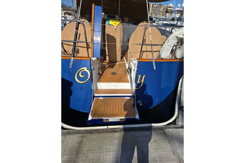 Slide: The Image of Tartan 4000 sailboat, 2016 model, docked with blue hull and wooden deck. - 26