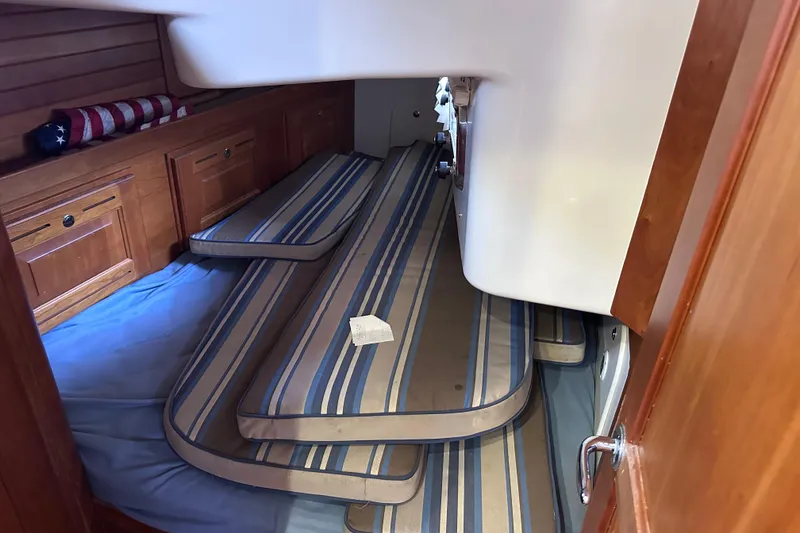 Slide: The Image of Interior cabin of 2016 Tartan 4000 sailboat with striped cushions and wooden cabinetry. - 38